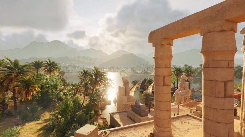 A sunlit landscape features ancient stone columns and statues, surrounded by lush palm trees and a reflective river, with distant mountains under a partly cloudy sky.