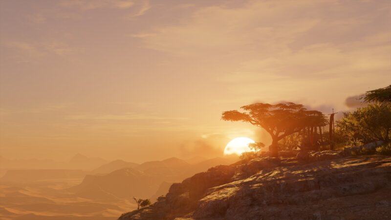 A vibrant sunset casts warm hues over a rocky landscape, with silhouetted trees and distant mountains creating a serene atmosphere in the foreground.