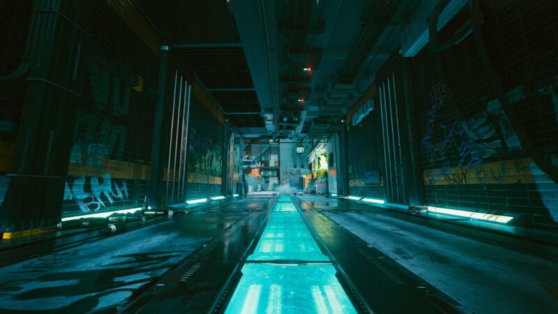 A futuristic alleyway features glowing cyan pathways, illuminated by neon lights and surrounded by urban graffiti on metallic walls, creating a cyberpunk atmosphere.