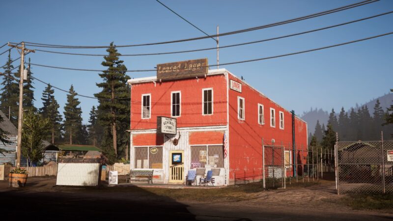 A bright red two-storey building with a sign reading "General Store" is surrounded by trees and utility poles, with a fence enclosing the property and a clear blue sky above.