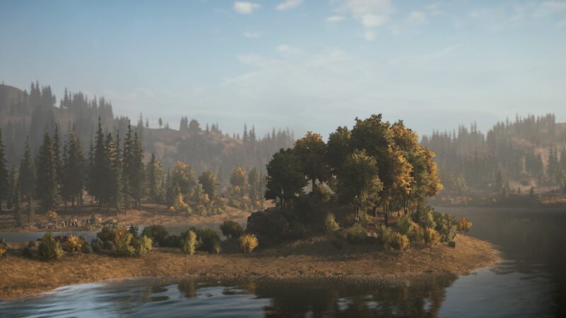 A serene lakeside scene features an island with lush, colourful trees surrounded by calm waters, framed by rolling hills and a clear blue sky.