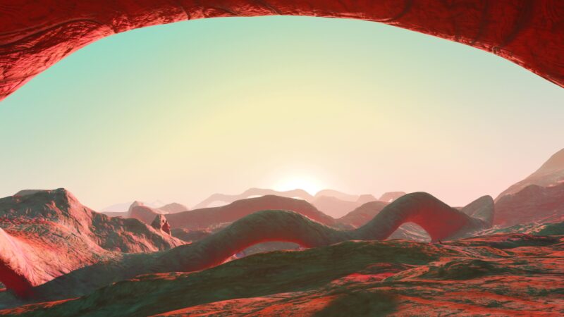 A vibrant alien landscape features rolling red hills under a pastel sky, with a sun rising in the background and an arching rock formation framing the scene.