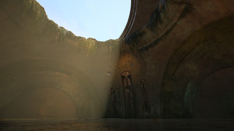 A vast, dimly lit cavern features large, curved stone walls with intricate carvings, moss-covered edges, and soft beams of light illuminating the damp atmosphere.