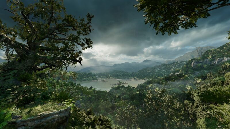 Lush, dense foliage frames a tranquil river valley, with dramatic clouds looming over distant mountains and hints of mist rising from the water's surface.