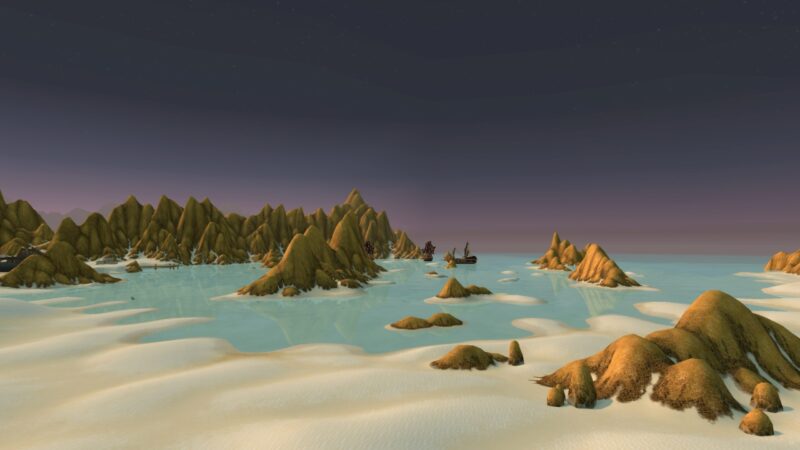 A serene landscape features golden-hued mountains rising above calm, turquoise waters under a twilight sky, with small sandy areas and distant silhouettes of ships.