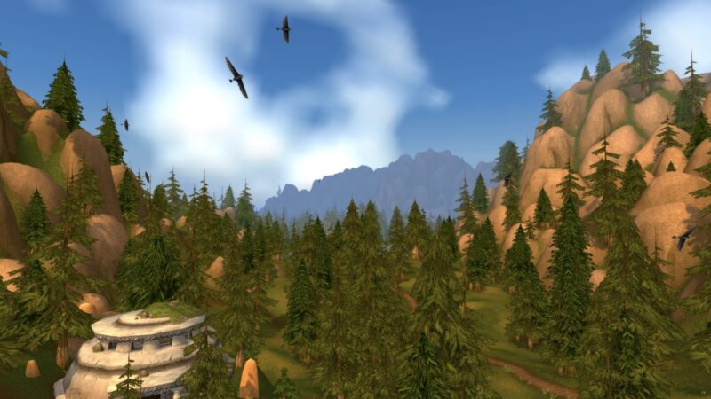 A lush landscape features towering pine trees, rocky mountains in the background, and a bright blue sky with scattered clouds, enhancing the vibrant, tranquil atmosphere.